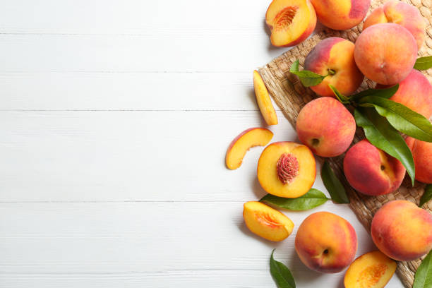 istock Fresh sweet peaches on white wooden table, flat lay. Space for text 1360146035
