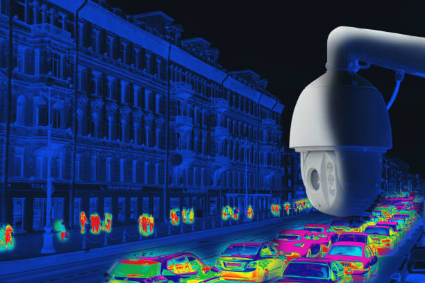 istock The concept of video surveillance and security technologies. Surveillance camera on the background of the city road with cars. Night. Tint 1360147664