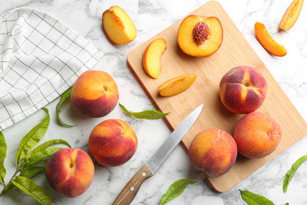 istock Flat lay composition with fresh sweet peaches on white marble table 1360147743
