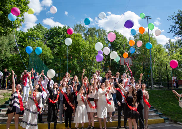 la place centrale, la dernière cloche des vacances scolaires. diplômés de l’école avec des balles. - fête de lécole photos et images de collection