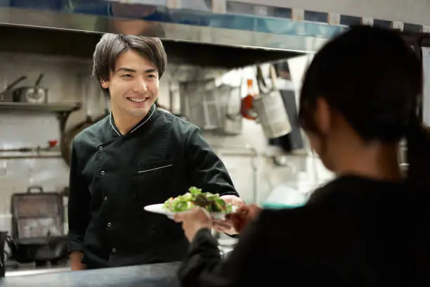 Photo of Asian cook cooking in a restaurant