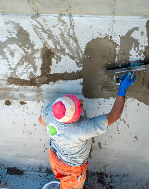 operaio edile che sparge malta tixotropica su muro di cemento con lesioni strutturali - trowel power concrete finishing foto e immagini stock