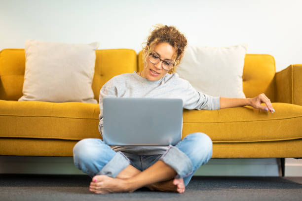 istock Young Woman Using Mobile Phone While Sitting On Sofa At Home 1360149106