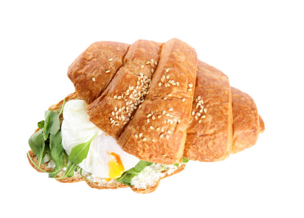 istock Delicious croissant with arugula and egg isolated on white, top view 1360149338
