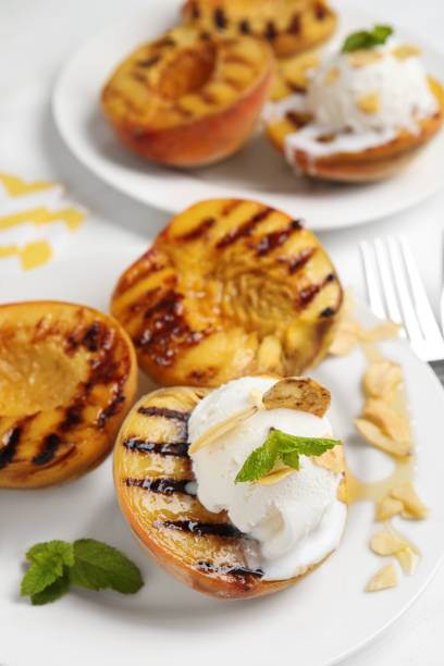 istock Delicious grilled peaches with ice cream served on white table, closeup 1360149689