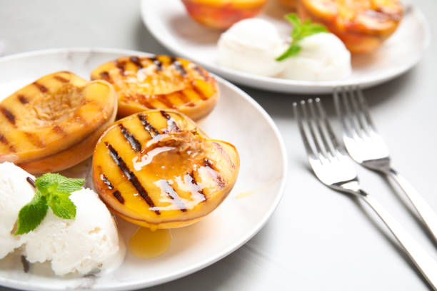 istock Delicious grilled peaches with ice cream and honey on grey table 1360149880