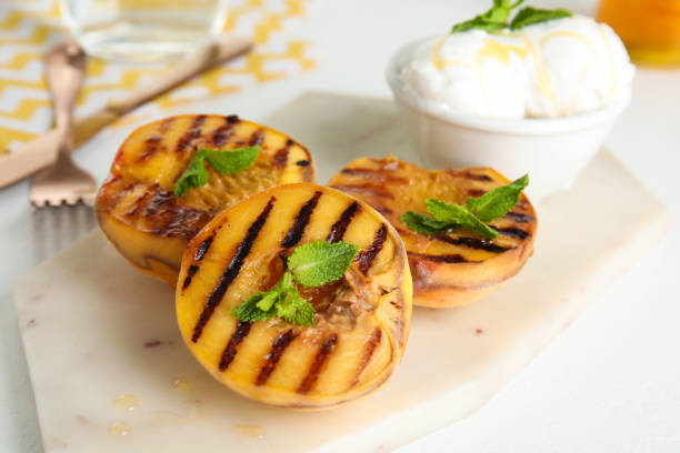 istock Delicious grilled peaches with honey and mint on white table, closeup 1360149967