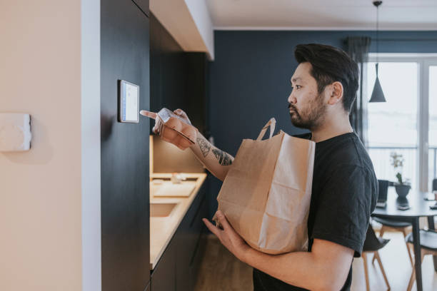 istock Japanese man loading groceries to smart fridge. 1360151079