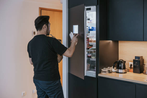 istock Japanese man loading groceries to smart fridge. 1360151081