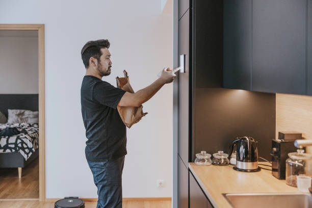 istock Japanese man loading groceries to smart fridge. 1360151083