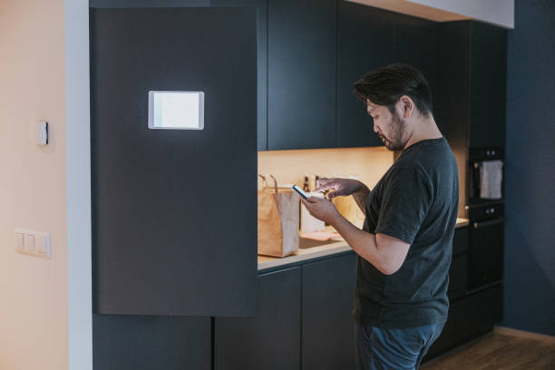 istock Japanese man loading groceries to smart fridge. 1360151087