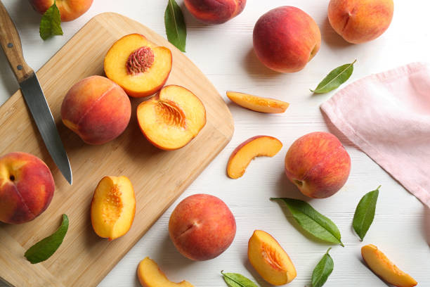 Flat lay composition with fresh sweet peaches on white wooden table