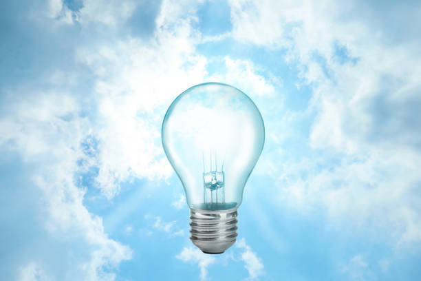 Solar energy concept. Glowing light bulb in sky as sun