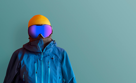 Skiing fashion. Man with ski jacket and goggles. Copy space for additional content.