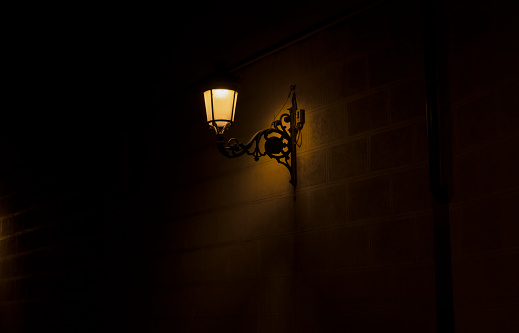 Street lamp on brick wall at night. Shot in Madrid, Spain