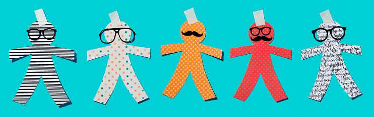 different paper man dolls on a blue background, as a prank for the innocents day, a feast held in some countries equivalent to april fools day, in a panoramic format to use as web banner or header