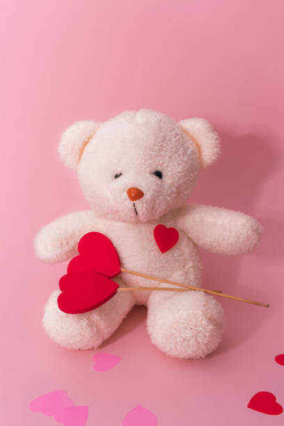 istock Cute white bear toy with red hearts on light pink background, space for text. Valentine's day celebration 1360155777