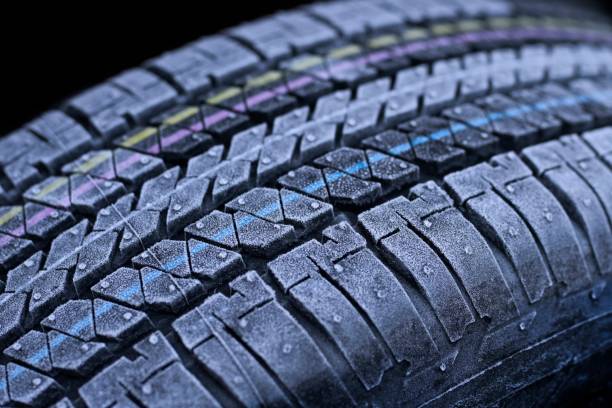istock Frosted car tire close-up wheel profile structure on black background. 1360155786