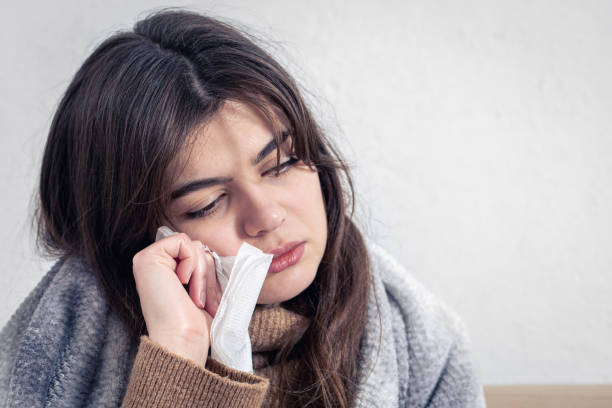 istock A sick young woman at home on the sofa with a cold, copy space. 1360155979