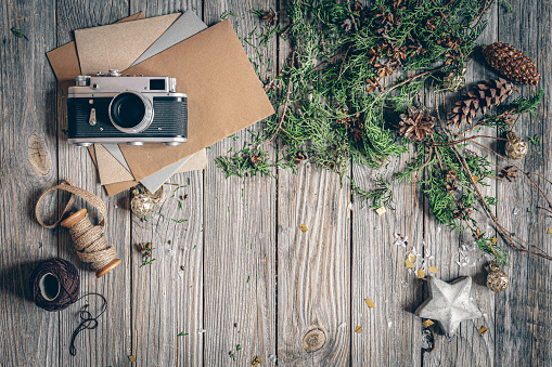 Vintage flat lay Christmas background with camera and letters on wooden surface, copy space.