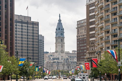 Cityscape of Philadelphia City Hall Clock Tower at summer day time, Pennsylvania, USA. Busy car traffic at business and cultural downtown