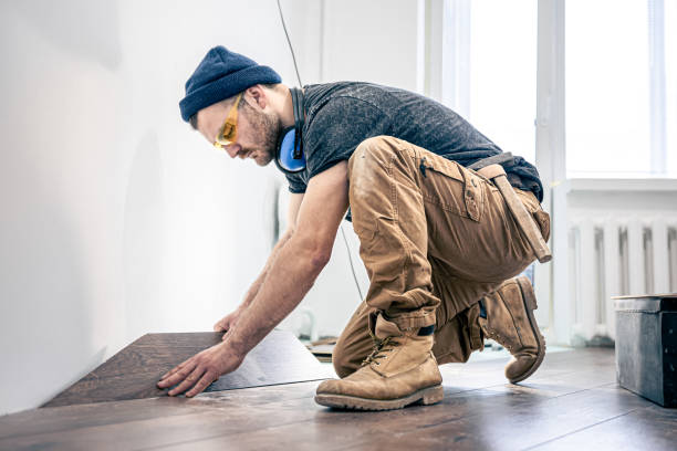 un lavoratore maschio mette pavimenti in laminato sul pavimento. - wood laminate flooring foto e immagini stock