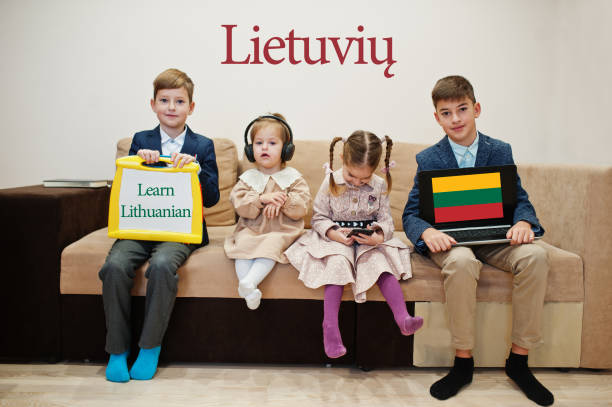 istock Four kids show inscription learn lithuanian. Foreign language learning concept. 1360157332