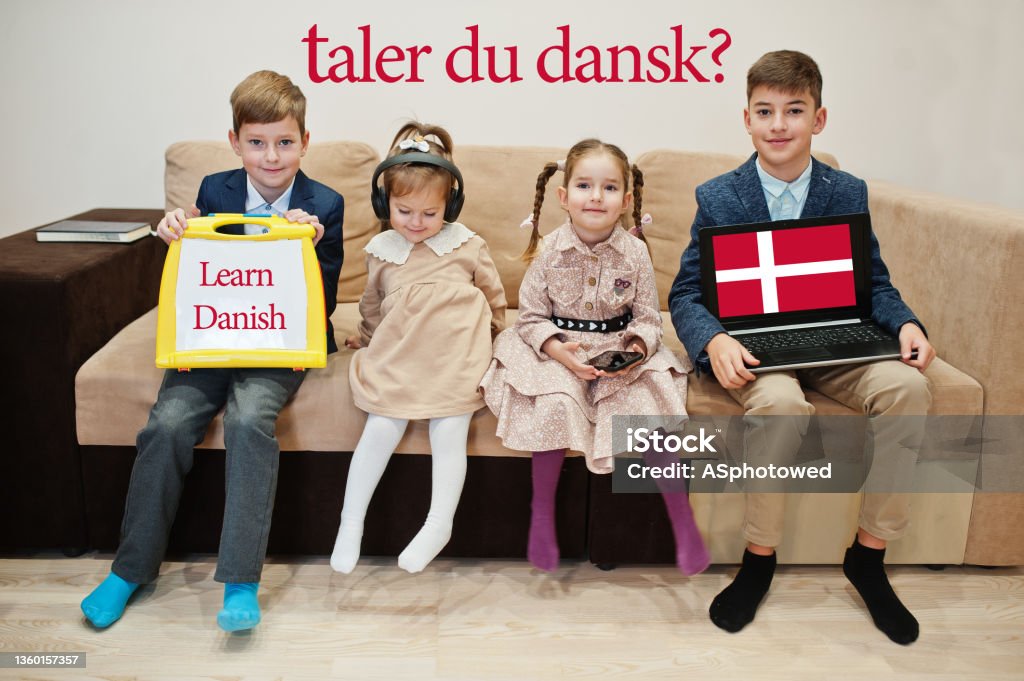 Four kids show inscription learn danish. Foreign language learning concept. Taler du dansk? 12-13 Years Stock Photo