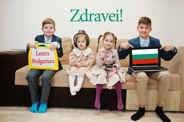 istock Four kids show inscription learn bulgarian. Foreign language learning concept. Zdravei! 1360157400