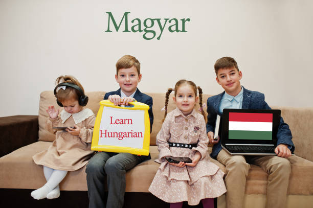istock Four kids show inscription learn hungarian. Foreign language learning concept. Magyar. 1360157403