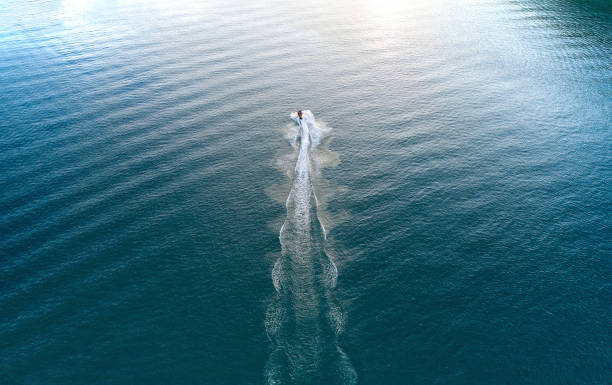 la persona sta cavalcando una moto d'acqua e avanzando attraverso l'acqua - recreational boat motorboat speedboat aerial view foto e immagini stock