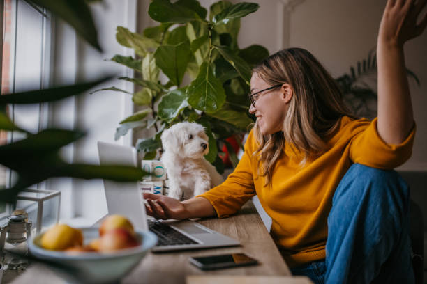istock Woman with dog at home 1360160354
