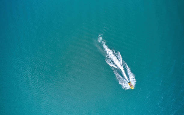 Aerial of the jet ski is moving through the water surface Aerial view of the jet ski is moving on the water jet boat stock pictures, royalty-free photos & images