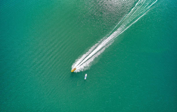 istock High angle view of high speed moving jet ski and canoe by side 1360161695