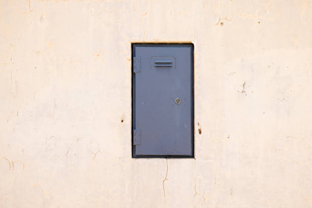 istock Small gray door in a concrete wall 1360162275
