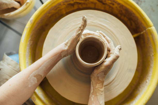 Hands of a potter. Potter making ceramic pot on the pottery wheel Hands of a potter. Potter making ceramic pot on the pottery wheel. pottery making stock pictures, royalty-free photos & images