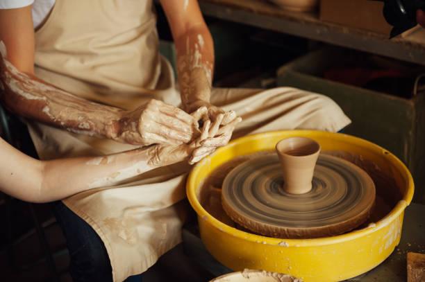 istock A couple in love creates a joint cup in a pottery workshop. Potter making ceramic pot on the pottery wheel 1360170155
