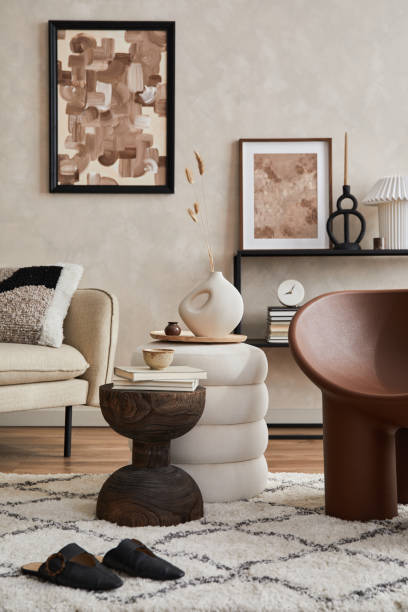 istock Modern composition of elegant living room interior design with mock up poster frame, sofa, armchair, pouf, console, coffee table, plants and stylish personal accessories. Copy space. Template. 