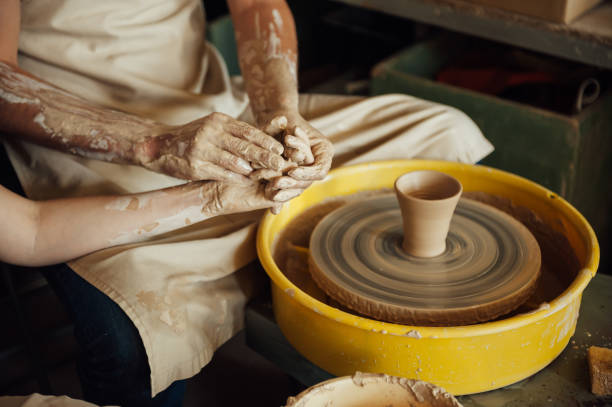 istock A couple in love creates a joint cup in a pottery workshop. Potter making ceramic pot on the pottery wheel 1360170206