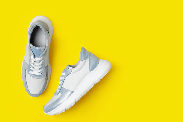 istock Stylish sneakers on yellow background, flat lay. Space for text 1360171134