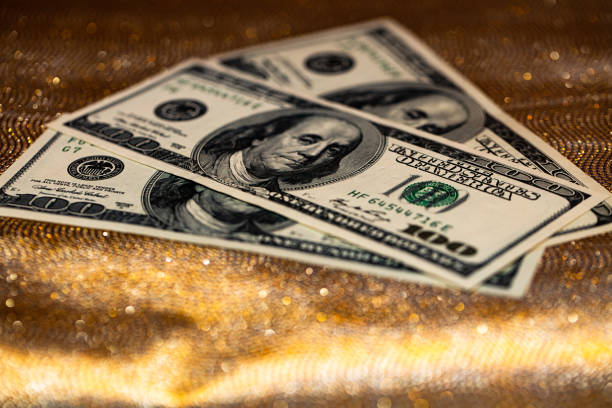 100 dollar banknotes on golden glitter background for design purpose