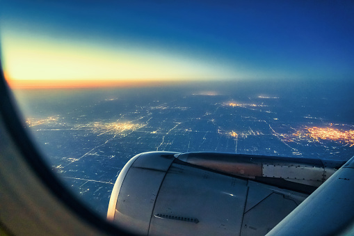 Passenger window view of commercial aircraft at sunset