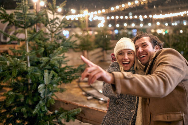 istock Lovely couple picking out Xmas tree; Xmas joy concept 1360176544