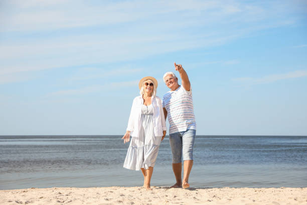 成熟したカップルは、海のビーチで一緒に時間を過ごす - senior adult retirement mature adult couple ストックフォトと画像
