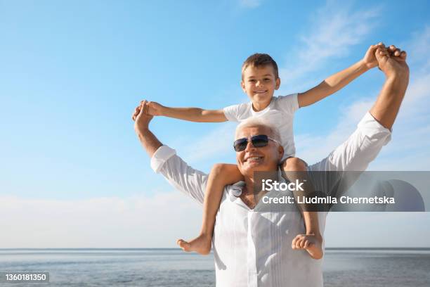 Cute Little Boy With Grandfather Spending Time Together Near Sea Stock Photo - Download Image Now