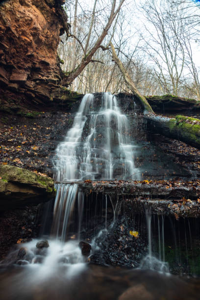 istock Tranquil waterfall scenery in the middle of autumn forest 1360181586