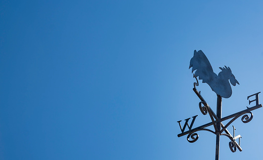 Weathervane against a clear blue sky in Cornwall.