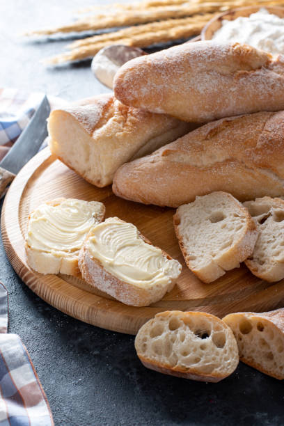 istock Fresh French Baguette Bread with butter on dark background 1360182932