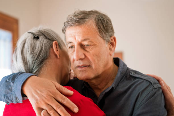istock Worried senior man embracing his wife 1360184575
