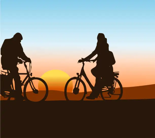 Vector illustration of silhouette of two cyclists with a sunset in the background